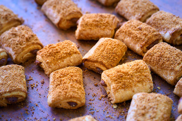 Freshly baked filled rolls featuring a crispy layer of crumb topping, perfect for dessert or snack time at a cozy bakery