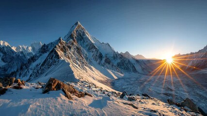 Majestic snow capped mountain peak at sunrise, showcasing a vibrant, starburst effect from the sun. The foreground displays a rocky, snow covered landscape. - Powered by Adobe
