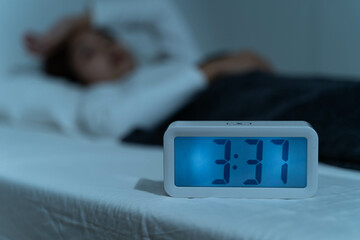 Young woman sleepless during night time on the bed.