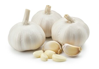 A close up of three garlic bulbs and several cloves on a white surface in a studio setting light