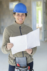 female engineer looking at blueprints in construction site