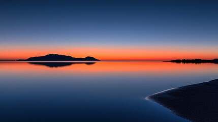 Fototapeta premium A serene sunset paints the sky above calm reflective waters