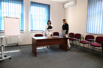 Two women meet to discuss a project and sign a contract.