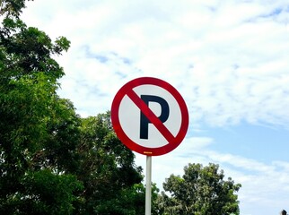 Sign says no parking here, on the side of the road