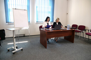 Two women meet to discuss a project and sign a contract.
