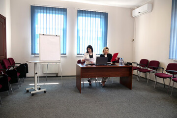 Two women meet to discuss a project and sign a contract.