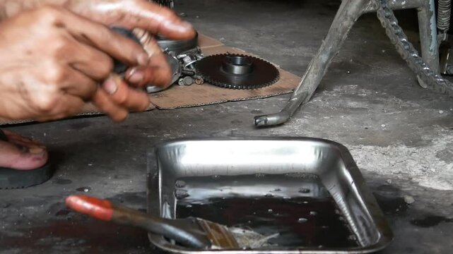 A motorcycle mechanic performs repairs and maintenance, cleaning on motorcycle pistons.
