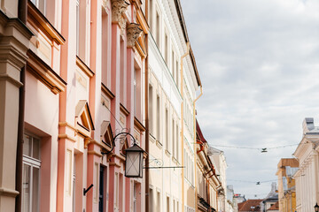 A charming European street lined with pastel-colored historic buildings, ornate architectural details, and a nostalgic atmosphere under a soft daylight sky