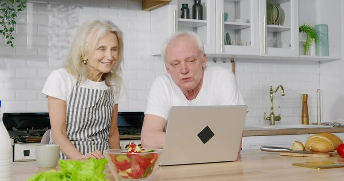 Portrait of cute grandma and granddad communicating by video call in laptop. Happy aged man and woman waving hands to web camera on computer, say bye-bye to friends or relatives, online communication
