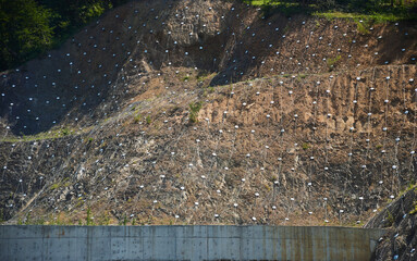 Reinforcement of the mountainside with a grid. Protection against landslides and destruction.