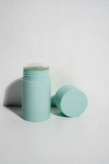 turquoise cylinder skincare product with the lid open on white background