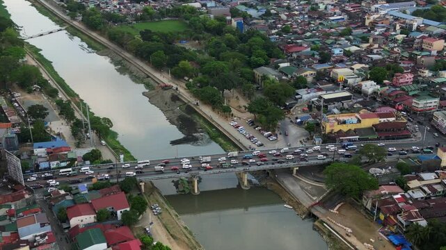 Marikina Bridge crossing packed with cars and trucks during rush hour overlooking Marikina River, Philippines -Aerial drone shot