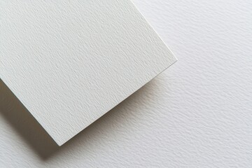 Close-up of textured white paper showcasing its subtle grain and edge detail for design use