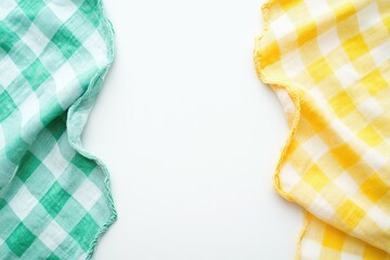 Two checkered cloths, green and yellow, draped on a white surface