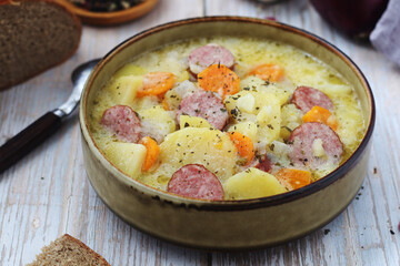 A bowl with traditional German potato soup with sausages	