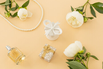 Women cosmetics set with costume jewelry and peony flowers.