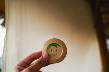 An adult holding a happy symbol, smiling, the idea of ​​living the present life happily and...