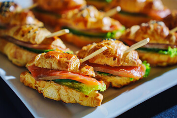 Delicious croissant sandwiches served on a white platter at a catering event