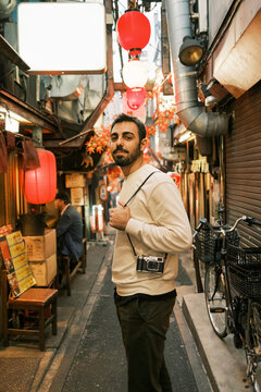 Photographer exploring a vibrant street in Tokyo at night