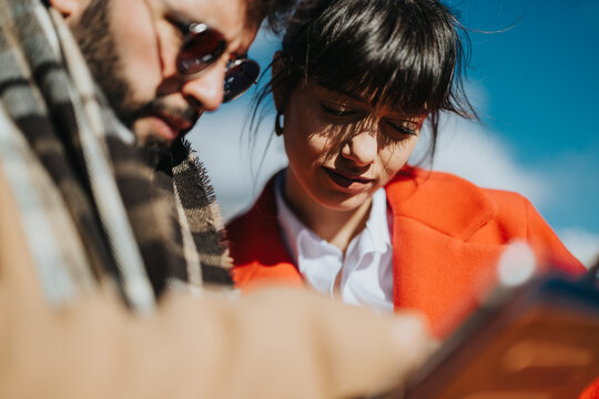 Two business individuals focus while discussing their project, capturing a professional yet casual vibe.