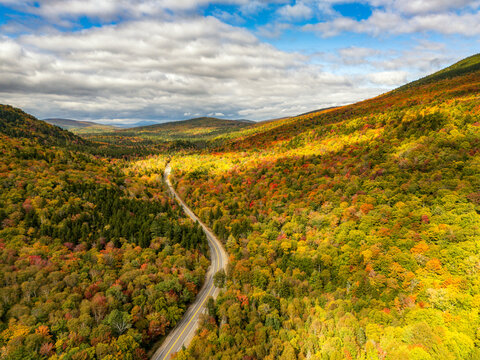 Aerial view of a scenic road through fall foliage in Grafton Notch, Maine