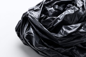 Crumpled Black Plastic Bag Texture - Abstract of a crumpled black plastic bag on a white background. Symbolizes waste, disposal, environmental issues, texture, and darkness