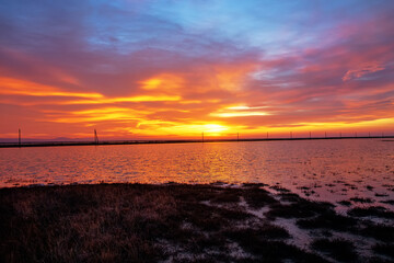 The sunset sky, the colors of the sun setting over the horizon on the clouds, lake