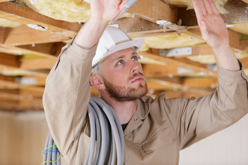 worker in the attic connects air ducts