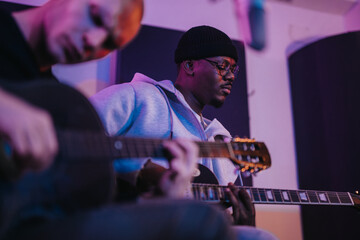 Two guitarists engrossed in a recording studio session, playing acoustic music with passion and...