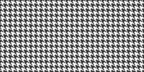 Classic houndstooth pattern in monochrome.  Elegant and versatile, ideal for textile design, fashion, website backgrounds, or print projects.  The repeating motif offers a timeless sophistication.