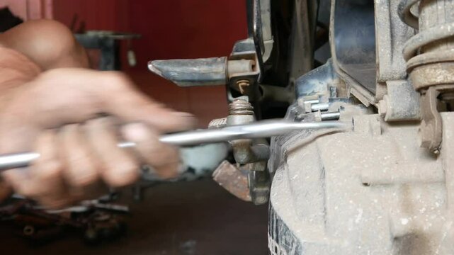 Motorcycle mechanic opens motorcycle CVT bolts using a T key. Motorcycle repair and maintenance