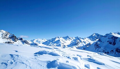 Obraz premium Deep blue sky framing rugged snowy summits, gentle snow flurries twisting through the high air, peaceful yet awe-inspiring landscape