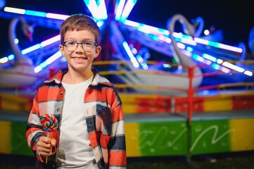 A handsome and happy boy is having fun in the amusement park