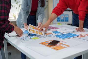 Uiux designers are working together to create a user friendly mobile application, discussing the...