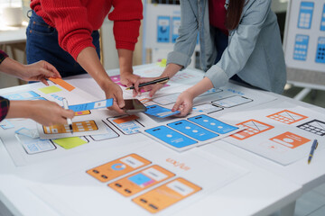 Web designers are working together to develop user interface and user experience of mobile...