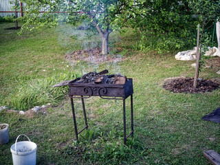 Firewood is burning in the courtyard of a rural house