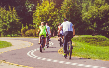 Fototapeta premium Cyclists ride on the bike path in the city Park 