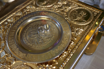 Wedding rings on a golden tray on a throne in a church. Church wedding.