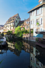 Naklejka premium half timbered crooked houses of Colmar with reflections in water, Alsace, France