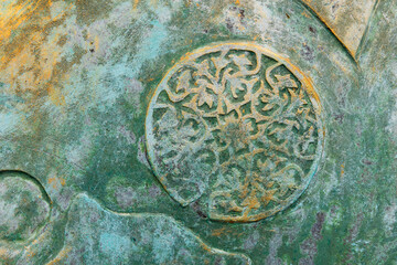 Weathered and textured surface featuring an intricate circular decoration