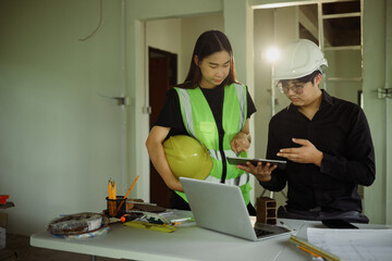 Male and female engineers reviewing construction plans in a renovation workspace
