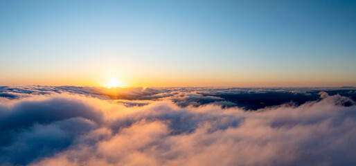 Beautiful sunset cloudy sky from aerial view. Airplane view above clouds