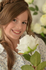 Pretty little girl smiling and posing with flowers