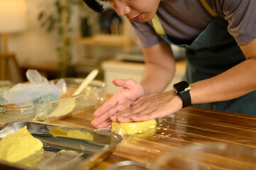 Man wearing black gloves forming compound butter for wrapping