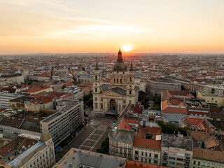 Dawn over St. Stephen Basilica shines golden sunrise, embraced by red rooftops building, elegant streets, and panoramic city views stretching horizon aerial view