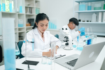 Modern medical scientists collaborate in a high-tech laboratory, analyzing chemical reactions and...