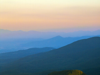 Pirin Mountains in Bulgaria glowing under radiant summer sunrise, drone capturing endless ridges,...