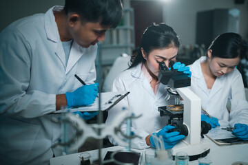 Modern medical scientists collaborate in a high-tech laboratory, analyzing chemical reactions and...