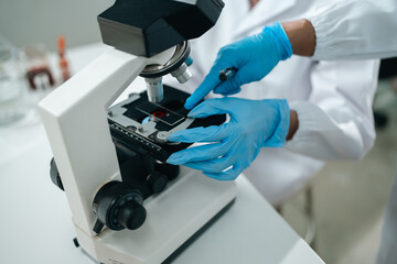 Medical research teamwork in modern laboratory using microscope and blood test tubes for DNA analysis, vaccine development showcasing scientific innovation in healthcare biotechnology