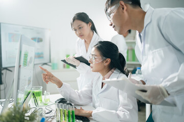 Laboratory research scientists analyzing data results using computer technology and digital charts...